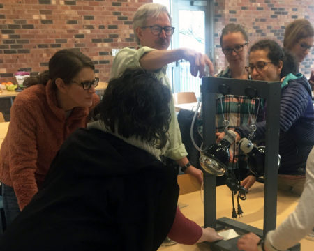 Everett area middle school teachers gather around a model that helps them simulate the enhanced greenhouse effect at an EarthGen Energy Matters training.