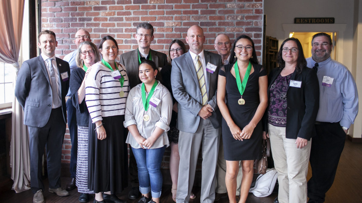 Large group of Oak Harbor Public Schools students and administrators posing with their green medals