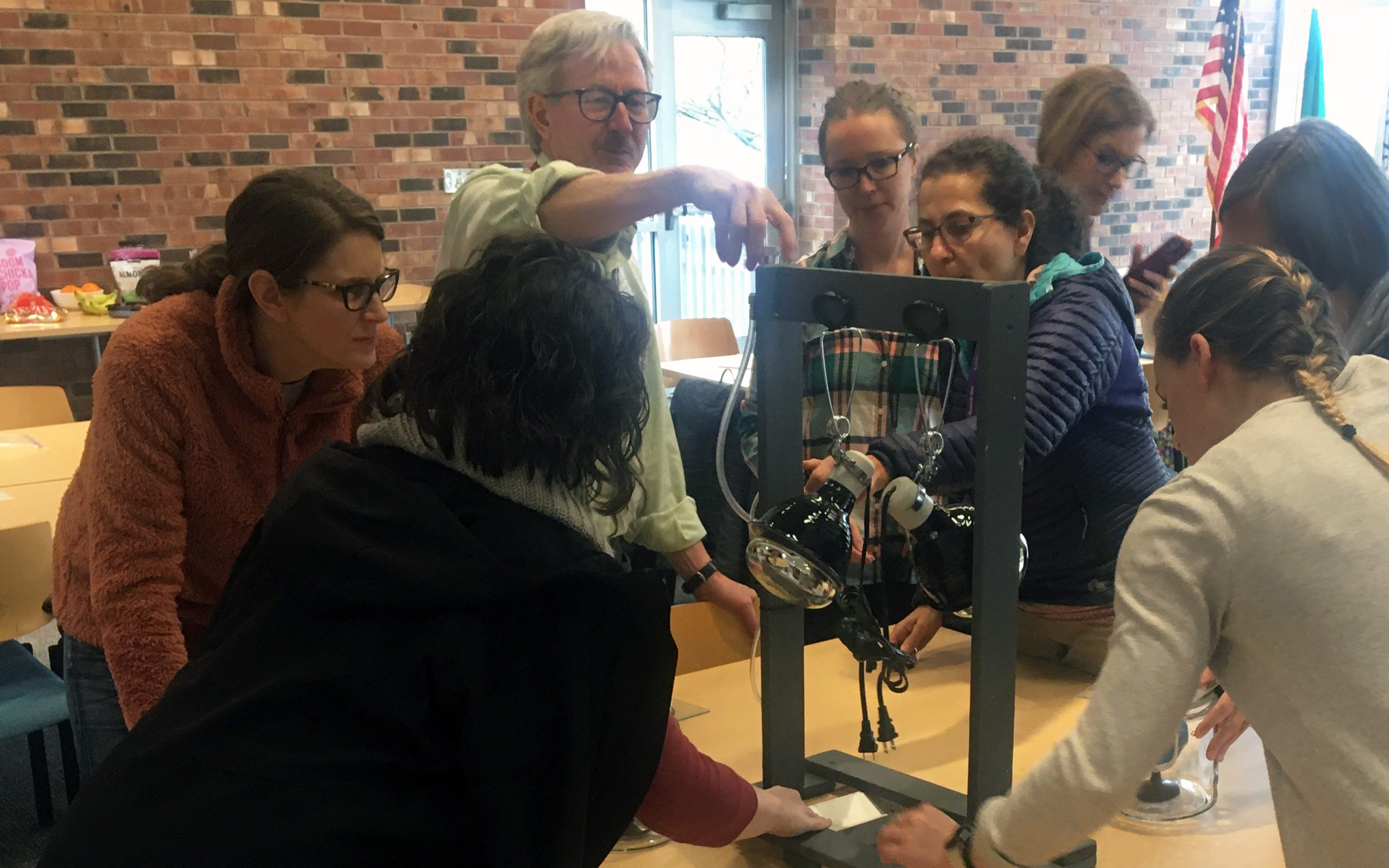 Everett area middle school teachers gather around a model that helps them simulate the enhanced greenhouse effect at an EarthGen Energy Matters training.  