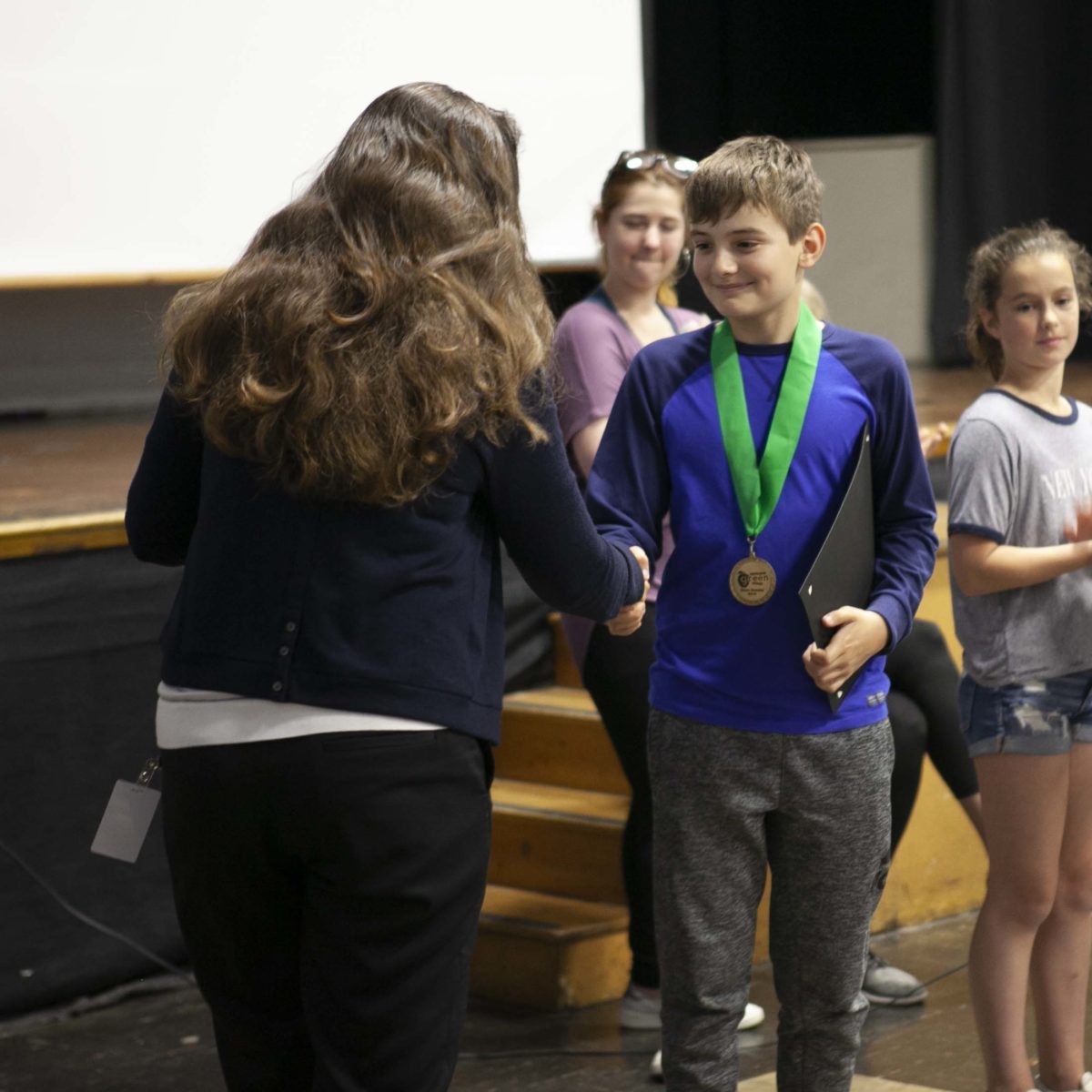 Finn shakes hands while receiving his Green medalist award