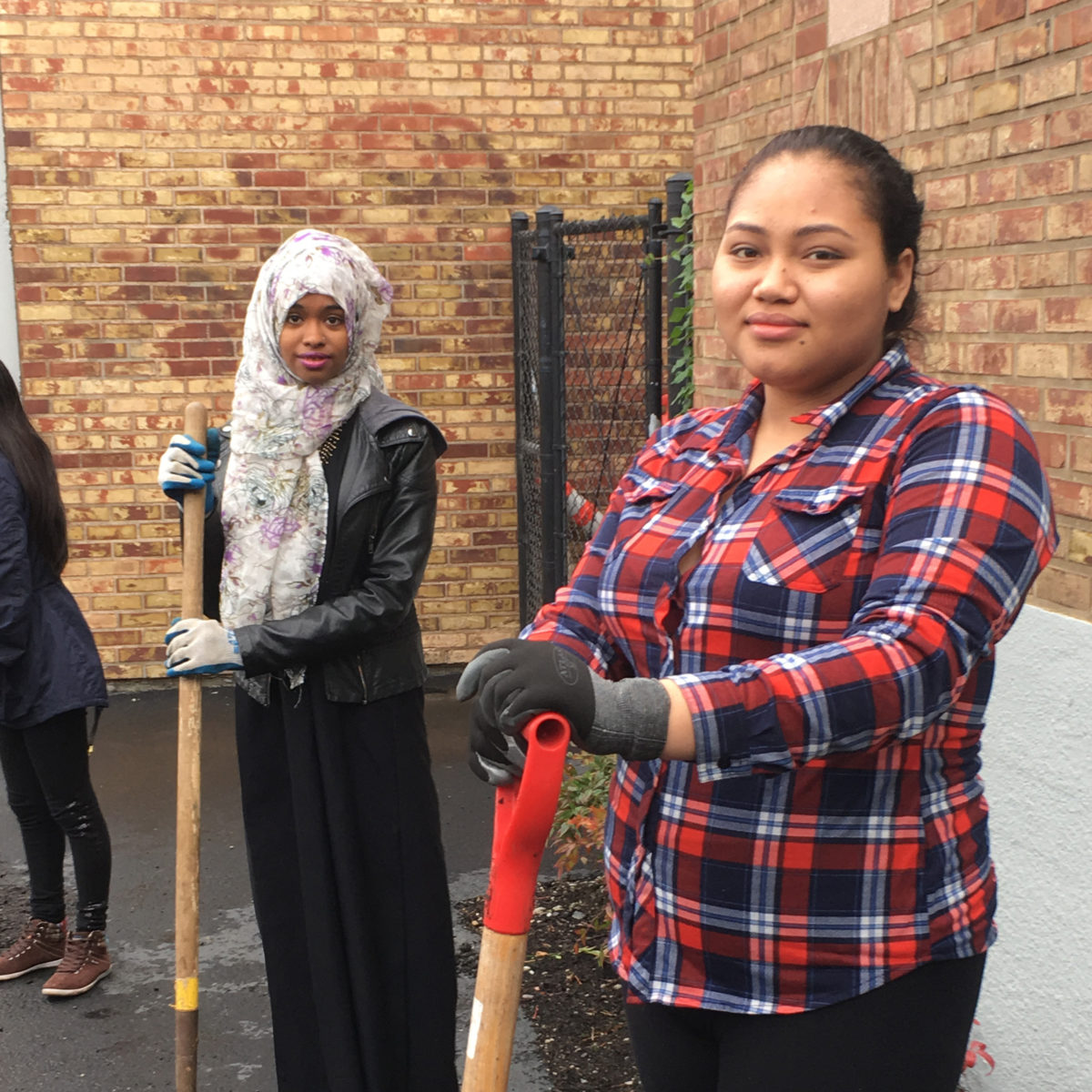 2 high school students pose with shovels