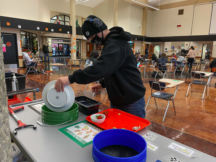 Washougal High School freshman Blake Early sorts his meal waste after eating lunch.