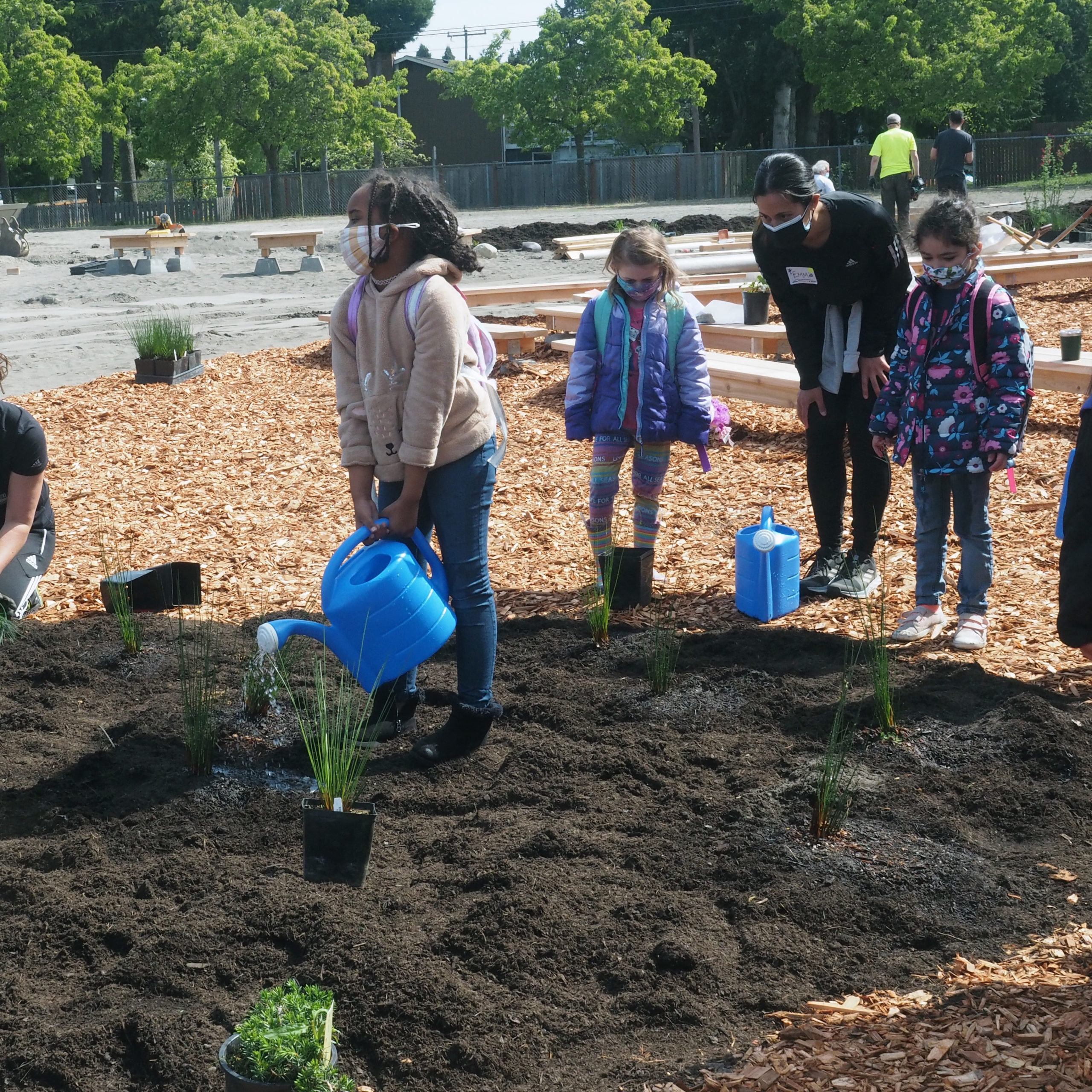 Seahurst Elementary students water plants in their new garden that borders their outdoor classroom.