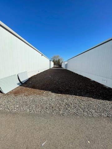 An empty gravel space between two grey portables