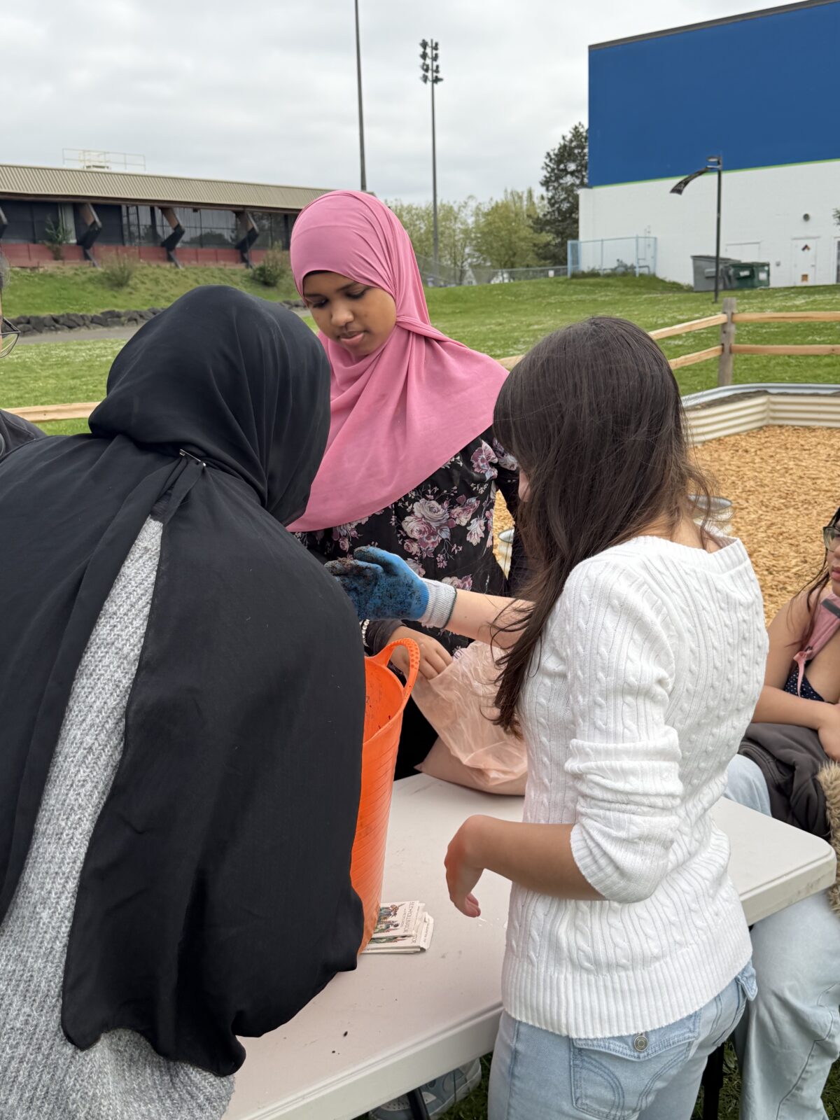 Ruweyda helps her classmates mix up their seed ball mixture