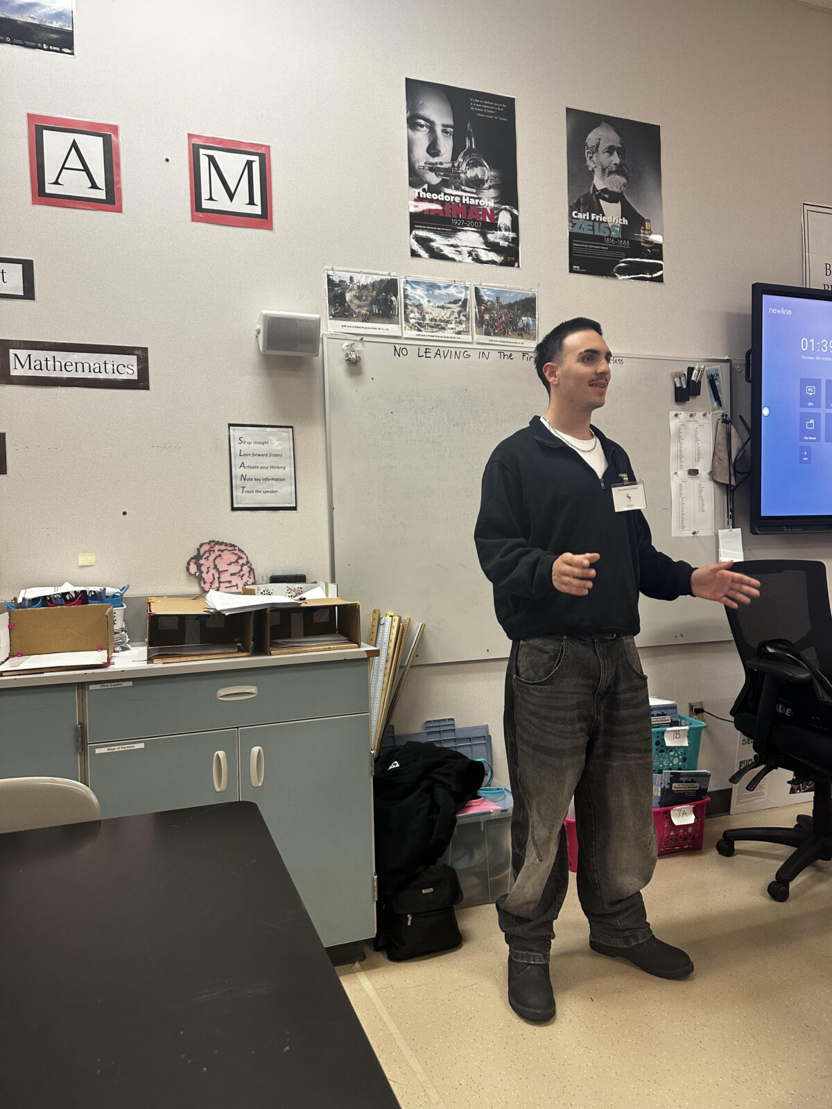 Sawyer stands up in the front of a middle school classroom.